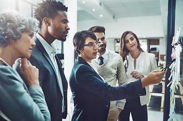 Image showing Business people, planning or woman writing on board for brainstorming or speaking of solution or team ideas. Group goals, sticky note or group meeting with leadership for problem solving together