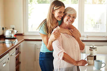 Image showing Mother, coffee or happy woman hugging in kitchen in family home bonding to enjoy time together. Embrace, affection or funny daughter relaxing or drinking tea with senior parent or mom in retirement