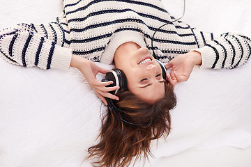 Image showing Relax, music and happy woman on bed with headphones from above, happiness and wellness in home. Audio, smile and girl in bedroom listening to streaming radio service or podcast with peace and freedom