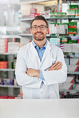 Image showing Medical, portrait and male pharmacist with crossed arms for confidence standing in a pharmacy clinic. Pharmaceutical, healthcare and mature man chemist by the counter of medication store dispensary.