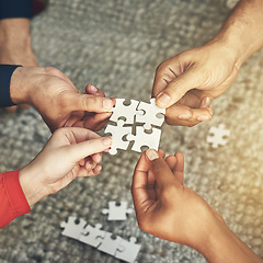 Image showing Hands, team and puzzle for teamwork or collaboration of business people for challenge or project. Above group of employees or friends building jigsaw together for solution, synergy or problem solving