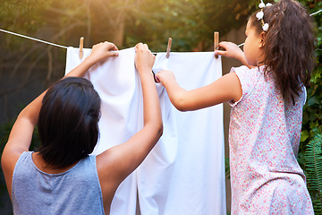 Image showing Teamwork, hanging laundry and a mother and child doing housework, chores and busy with clothes. Cleaning, family and back of a little girl helping mom with clothing on the line in backyard together