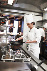 Image showing Chef, woman and frying pan in restaurant kitchen, catering service and prepare food for fine dining. Professional, cooking and female person saute meat for meal, diet and nutrition for hospitality.