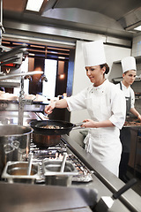 Image showing Chef, woman and frying pan with sauce in kitchen, catering service and prepare food for restaurant fine dining. Professional, cooking and female saucier, cook or person with meat meal for hospitality