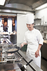 Image showing Chef, woman and frying pan in restaurant kitchen, catering service and prepare food for fine dining. Professional, cooking and female cook or person saute meat, making meal and smile for hospitality.