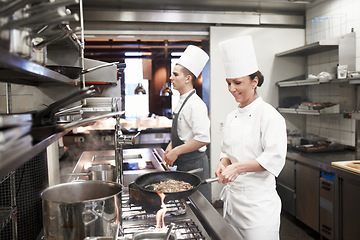 Image showing Chef, woman and frying in restaurant kitchen, catering service and prepare food for fine dining. Professional, cooking and female person saute meat with cook pan making meal nutrition for hospitality