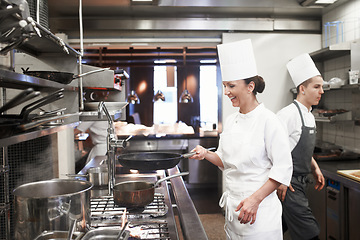Image showing Chef, woman and smile with frying pan in kitchen, catering service and prepare food for fine dining in restaurant. Professional, cooking and female person saute, cook and working for hospitality.