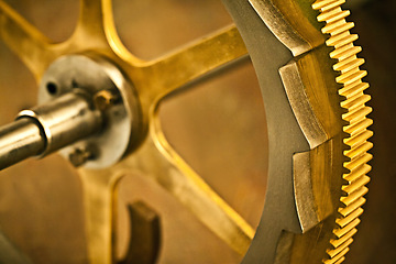 Image showing The mechanics of time. Clock gear, gold and vintage wheel cog of golden machinery and gears. Metal, closeup and steel with machine detail and maintenance with retro brass parts and wheels.