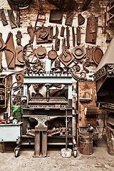 Image showing Workshop, metal tools and forge with wall background for industry, vintage manufacturing and development. Retro factory, workspace and industrial for steel, iron and production for craftsmanship