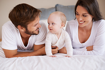 Image showing Happy family, dad and mom with baby on bed for love, care and quality time together at home. Mother, father and cute newborn child relaxing in bedroom for happiness, support and development of kids