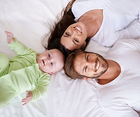 Image showing Top view portrait of mother, father and baby on bed for love, care and quality time together at home. Happy parents, family and cute newborn kid relax in bedroom with smile, support and fun bonding