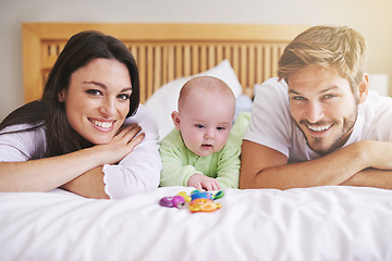 Image showing Portrait, mother and father with baby on bed for love, care and quality time together. Happy parents, family and newborn child playing with rattle toys in bedroom, bonding and fun development at home