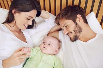 Image showing Top view, parents and smile of baby in bedroom for love, care and quality time together at home. Happy mother, father and family relax with cute newborn kid on bed for support, development and joy