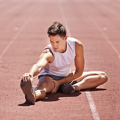 Image showing Athlete, stretching and man outdoor for exercise, running or workout at sports stadium. Male runner or sport person on ground training legs and body for fitness, competition and wellness on track