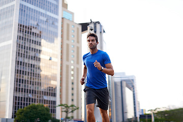 Image showing Sports, exercise and man running in the city for health, wellness or training for a marathon. Fitness, runner and male athlete doing an outdoor cardio workout for endurance or speed in an urban town.