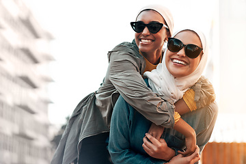 Image showing Muslim woman, friends and piggyback in city with freedom, youth and urban travel together in Qatar. Islamic women, happiness and walking in metro with funny game, sunglasses and comic journey