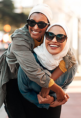 Image showing Islamic woman, friends and piggyback in city with freedom, youth and comic adventure together in street. Muslim women, happy and walking in metro with funny game, sunglasses and support in Qatar