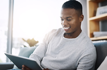 Image showing Living room, tablet and happy man on couch browsing social media meme, email or streaming video subscription service. Happiness, internet and guy networking with smile on face reading website on sofa