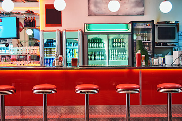 Image showing Retro, vintage and stools with interior in a diner, restaurant or cafeteria with funky decor. Trendy, old school and chairs by a counter or bar in groovy, vibrant and stylish old fashioned empty cafe