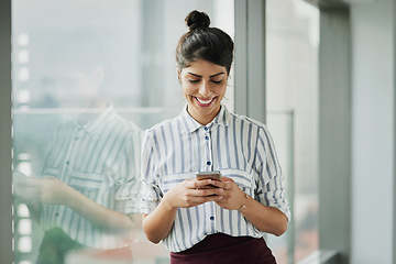 Image showing Business woman, smile and phone text with happiness at office window with a email. Young female face employee and mobile connection of a worker feeling happy on social media and technology at company