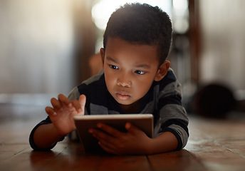 Image showing Learning, little boy and on digital tablet or playing games or streaming video on the internet and lying on the floor at home on bokeh. Technology, device and male child downloading app or reading