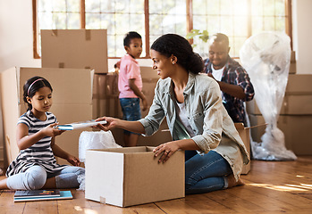 Image showing Boxes, moving and family packing in home living room together with children, mom and dad. Property, real estate investment and house move with couple, kids helping box and cardboard unpacking