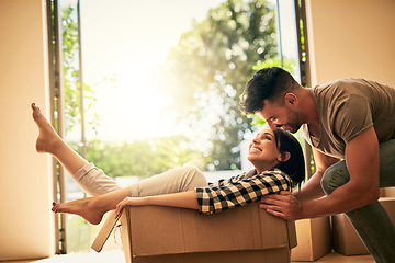 Image showing New home, smile and couple pushing box, having fun and bonding in apartment. Real estate, happiness and man and woman in cardboard, play and enjoying quality time together while moving into property.