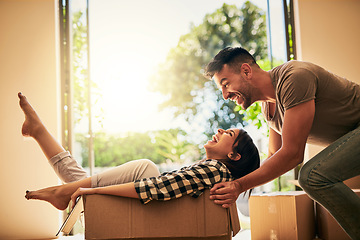 Image showing New house, funny and couple pushing box, having fun and bonding in apartment. Real estate, laughing and man and woman in cardboard, play and enjoying quality time together while moving into property.