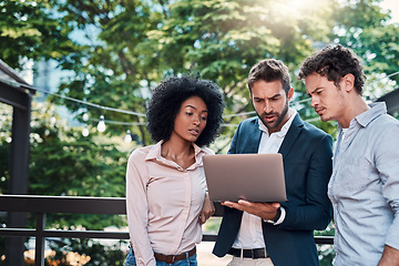 Image showing Collaboration, laptop and business people together outdoor, working and brainstorming. Teamwork, computer and group of employees, men and black woman planning, meeting and serious cooperation in city