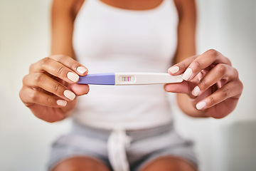 Image showing Hands, woman and closeup of a positive pregnancy test by a woman in the bathroom of her home. Maternity, motherhood and zoom of a female person with a pregnant device in her modern house or apartment