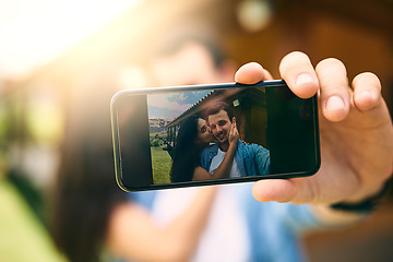 Image showing Happy couple, kiss and phone camera for selfie, photo or profile picture together in relationship outdoors. Hand of man holding smartphone with woman kissing cheek for love, memory or capture outside