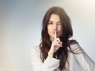Image showing Woman, studio portrait and secret with finger on mouth for beauty deal, wink eye or icon for silence by background. Isolated model girl, cosmetics flirt or hand sign with emoji, whisper and makeup