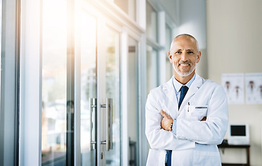 Image showing Mature doctor, smile and portrait with arms crossed in hospital feeling proud from medical work. Healthcare, wellness and professional employee with happiness from health support and physician job