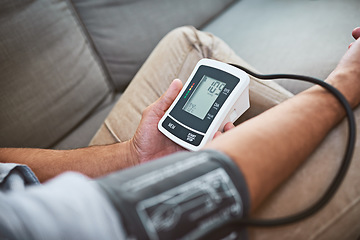 Image showing Hypertension, machine and person test blood pressure in a home sofa or living room for medical or health exam. Monitor, reading and man with closeup of equipment for chronic disease due to stress