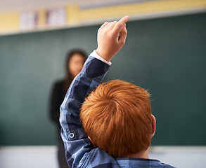 Image showing Child, question and student in classroom with question for teacher, education and learning with school blackboard. Boy, raise arm and questions for knowledge, information and development in class