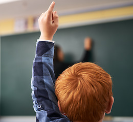 Image showing Student, hand and child in classroom with question for teacher, education and learning with school blackboard. Boy, raise arm and questions for knowledge, information and development in class