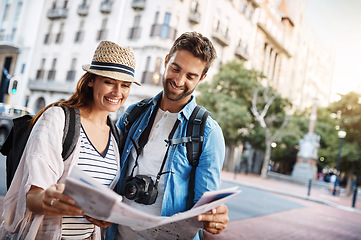 Image showing Couple, tourist and a map in a city for travel on a street for direction or location search. Man and woman together with paper for navigation outdoor on urban road for adventure, journey or vacation