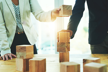 Image showing Teamwork, building blocks and business people in office, design challenge and problem solving at startup. Engineering, architecture and strategy with wood block game, man and woman working together.