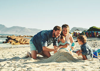 Image showing Sandcastle, parents and children at the beach with bonding, love and support. Baby, mom and dad together with kids playing in the sun with happiness and smile by the ocean and sea with family