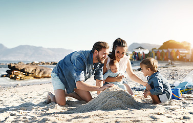 Image showing Sandcastle fun, parents and children at the beach with bonding, love and support. Baby, mom and dad together with kids playing in the sun with happiness and smile by the ocean and sea with family