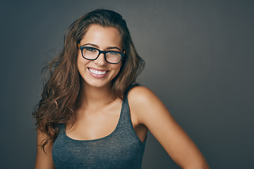 Image showing Woman, glasses and portrait with happiness and mockup from eyewear. Gray background, studio and mockup with young female person and model with beauty and casual style with a smile and eye care