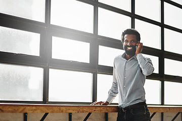 Image showing Window, smile and phone call with a business man talking in the office while networking for negotiation. Happy, mobile and communication with a happy male employee standing at work during his break