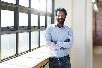 Image showing Portrait, window and smile with a business man arms crossed in the office, feeling positive about future success. Mindset, vision and happy with a male employee standing at work during his break