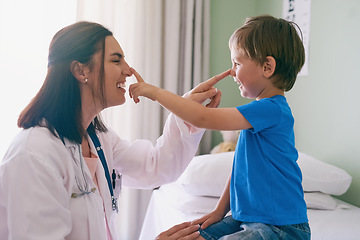 Image showing Woman doctor, playing and child at a hospital for healthcare and medical consultation. Fun, nose poke and pediatrician working with a laugh and happiness in a clinic with boy patient with exam