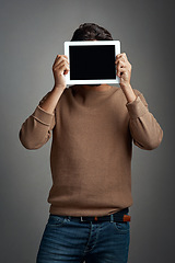 Image showing Tablet screen, space and man covering face in studio isolated on a gray background. Touchscreen, hiding and male person with mockup for marketing, advertising and technology for commercial promotion.