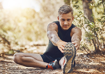 Image showing Man is stretching legs, running in forest and fitness with cardio, workout and training outdoor. Young male athlete, runner with warm up and ready to start run, exercise in nature with sport shoes