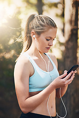 Image showing Woman with earphones, phone and fitness with music outdoor, listening for motivation on run in park. Female runner with song choice on mobile, podcast or radio streaming for exercise and health