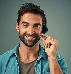 Image showing Happy man, headphones and portrait of a call center consultant against a grey studio background. Face of friendly male consulting agent smiling with headset in contact us, customer service or advice