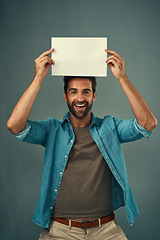 Image showing Happy man, portrait and mockup billboard for advertising, marketing or branding against a grey studio background. Male person holding rectangle poster, placard or board for sign or advertisement