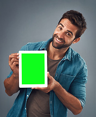 Image showing Happy man, portrait and tablet with green screen for advertising, marketing or branding against a grey studio background. Male person showing technology display, chromakey or mock up in advertisement